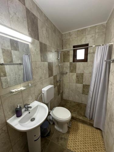 a bathroom with a white toilet and a sink at Casa Militaru in Murighiol