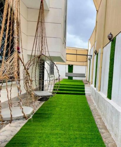 a hallway with green grass and a building at كمباوند شاليهات فابيلوس 