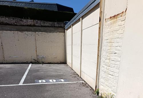 an empty parking lot next to a brick wall at Studio des mers in Le Tréport