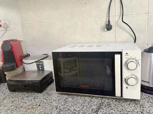 un forno a microonde seduto sopra un bancone della cucina di BlessyWail Homestay a Mascate