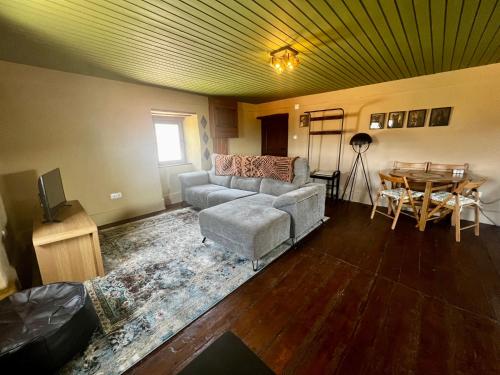 a living room with a couch and a table at Casa de Montanha in Figueiró dos Vinhos