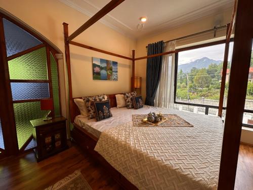 a bedroom with a large bed with a large window at Silver Woods- A Boutique Cottage in Srinagar