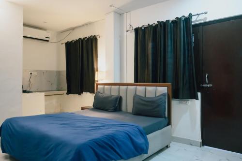 a bedroom with a bed with blue sheets and a window at Urban Loft Hostel in Rishīkesh