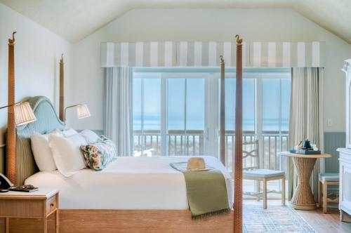 a bedroom with a bed with a view of the ocean at The Sanderling in Duck