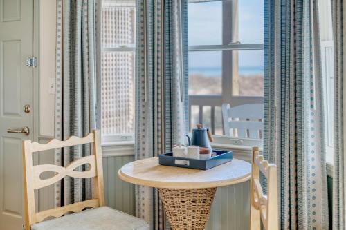 a table and a chair in a room with a window at The Sanderling in Duck