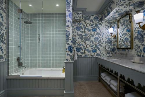 a bathroom with a tub and a shower with blue and white tiles at The Sanderling in Duck