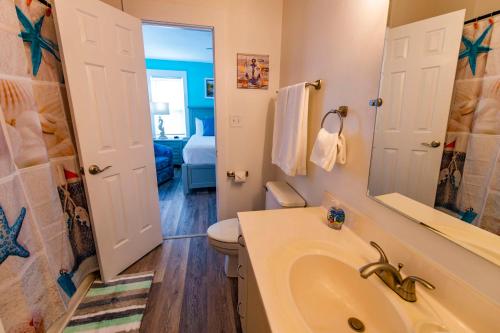 a bathroom with a sink and a toilet and a mirror at The Sanderling in Duck
