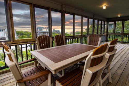 a wooden table and chairs on a screened in porch at The Sanderling in Duck