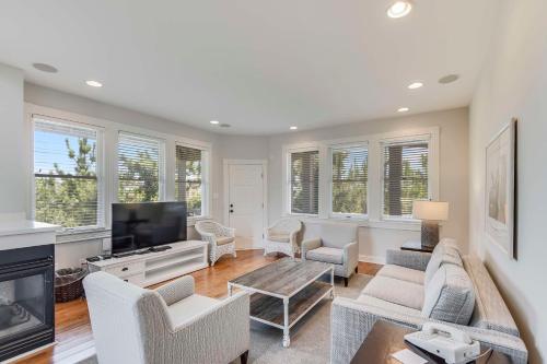 a living room filled with furniture and a flat screen tv at The Sanderling in Duck