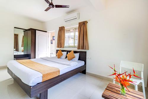 a bedroom with a large bed and a chair at Elegant 4Bhk Stay With Pool Near Beaches 2BHKX2 in Vagator