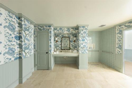 a bathroom with blue and white wallpaper and a sink at The Sanderling in Duck