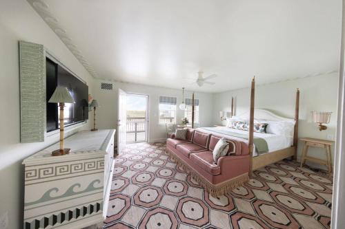 a large bedroom with a bed and a couch at The Sanderling in Duck