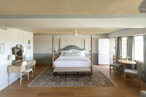 a bedroom with a canopy bed and a table and chairs at The Sanderling in Duck