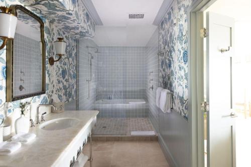 a bathroom with a tub and a sink and a shower at The Sanderling in Duck