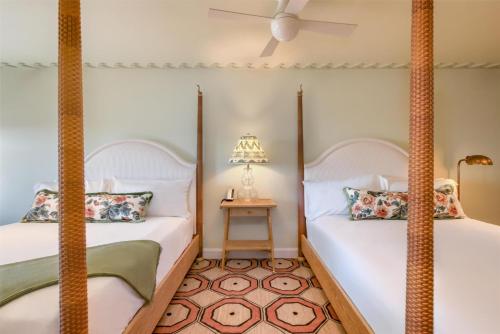two beds in a room with a lamp and a table at The Sanderling in Duck
