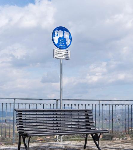 a bench in front of a fence with a sign at Mavianto in Torre le Nocelle