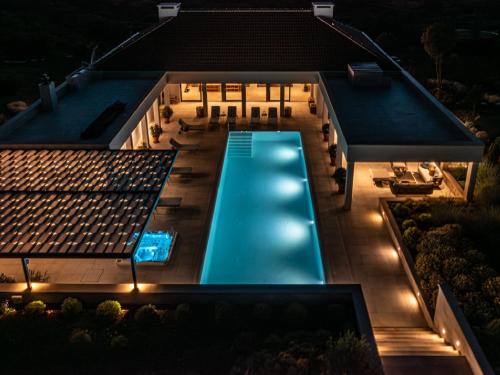 una vista dall'alto di una piscina di notte di Spectacular Brac Villa Villa Adriatic 5 Bedrooms Stunning Sea Views & Infinity Pool & Private Gym Skrip a Supetar (San Pietro di Brazza)