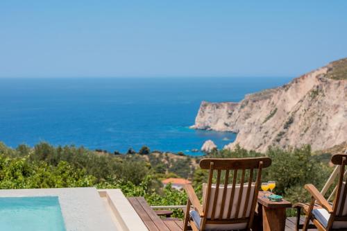a table and chairs with a view of the ocean at Arca Villa - Enchanting Sunset! in Keri