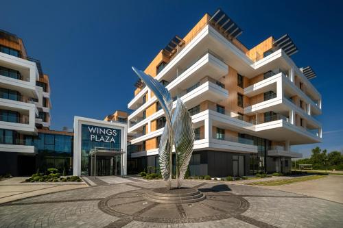 a large building with a statue in front of it at Wings Plaza in Kraków
