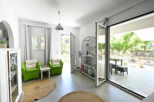 a living room with green chairs and a sliding glass door at Anchor Villa in Troulos