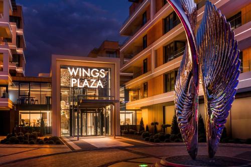 a building with a sign that reads wings plaza at Wings Plaza in Kraków