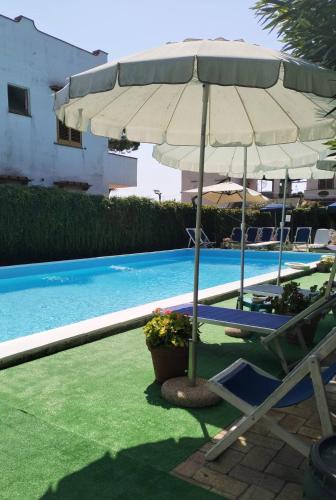 a pool with an umbrella and a chair and a chair and a table at Villa Dafne in Forio d'Ischia