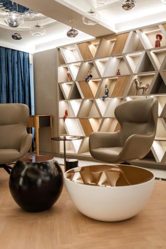 a room with chairs and a wall of shelves at Wings Plaza in Kraków