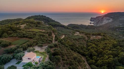 an aerial view of a house on a hill with the sunset at Arca Villa - Enchanting Sunset! in Keri