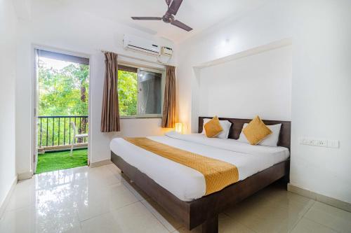 a bedroom with a large bed and a balcony at Elegant 4Bhk Stay With Pool Near Beaches 2BHKX2 in Vagator