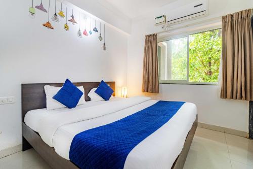 a bedroom with a large bed with blue pillows at Elegant 4Bhk Stay With Pool Near Beaches 2BHKX2 in Vagator