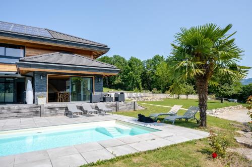 une maison avec une piscine et un palmier dans l'établissement Gite la Quintessence, à Nonglard