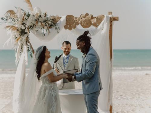 a bride and groom officiating a wedding on the beach at Tombo Beach in Guarujá