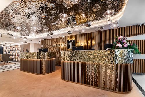 a lobby with a gold and black reception desk at Wings Plaza in Kraków