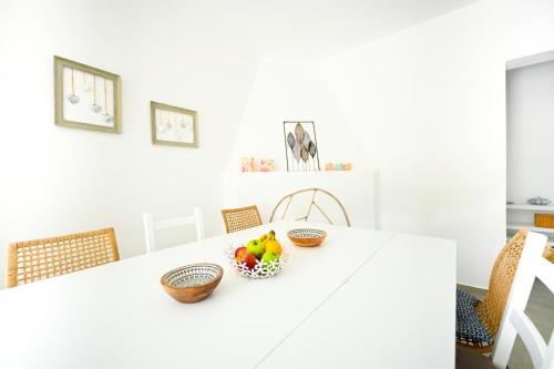 a white kitchen with a table with baskets of fruit at Anchor Villa in Troulos