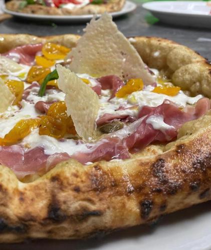 a pizza sitting on top of a white plate at Agriturismo Crilù in Milazzo