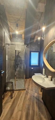 a bathroom with a shower and a sink and a mirror at Crimea Wine Hotel in Chiavenna