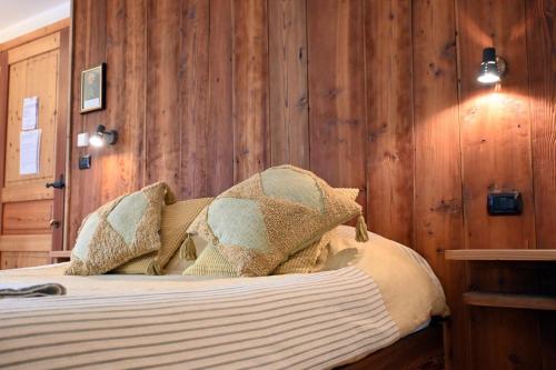 a bedroom with wooden walls and a bed with pillows at Agriturismo Au Jardin Fleuri in Antey-Saint-André