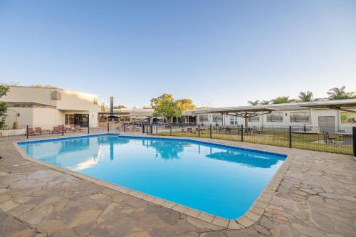 a large swimming pool with blue water at Safari Lodge in Windhoek