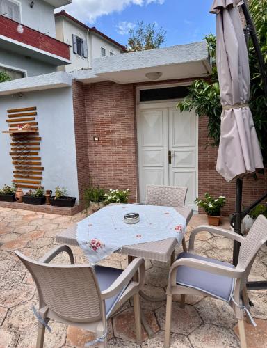 a patio with a table and chairs and an umbrella at Villa Adams in Përmet