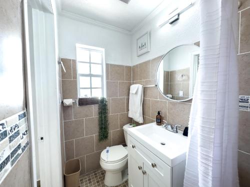 un bagno con lavandino, water e specchio di 2q Beds Studio Apt With Shared Pool 03 a Clearwater