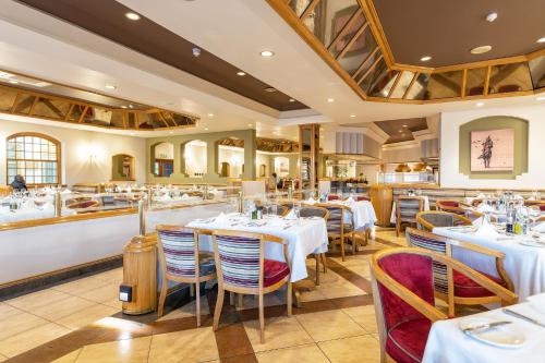 a restaurant with tables and chairs in a room at Safari Lodge in Windhoek