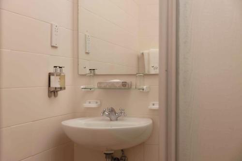 a bathroom with a sink and a mirror at Safari Lodge in Windhoek