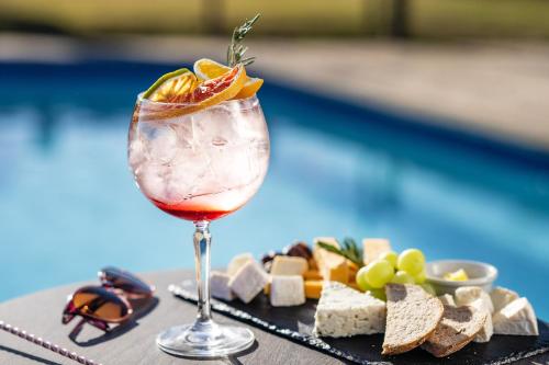 a drink in a glass next to a plate of food at Safari Lodge in Windhoek