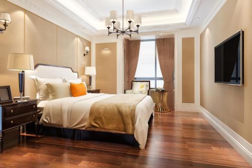 Un dormitorio con una cama grande y un televisor. en Hotel Emerald Park At Airport, en Nueva Delhi