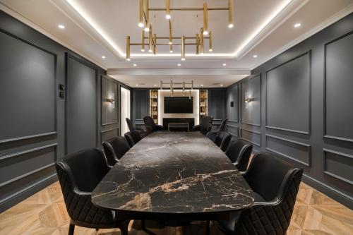 a conference room with a large black table and chairs at Wings Plaza in Kraków