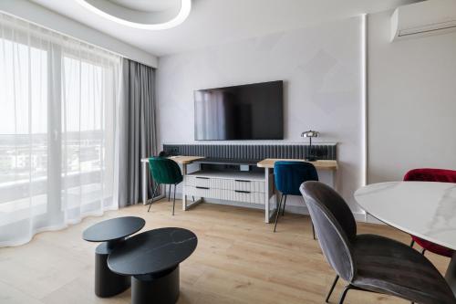 a living room with a table and chairs and a tv at Wings Plaza in Kraków