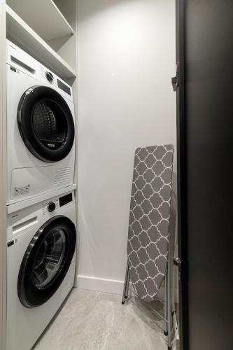 a laundry room with a washer and a washing machine at Wings Plaza in Kraków