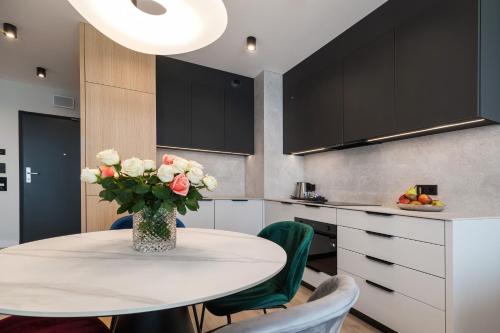 a kitchen with a table with a vase of flowers at Wings Plaza in Kraków