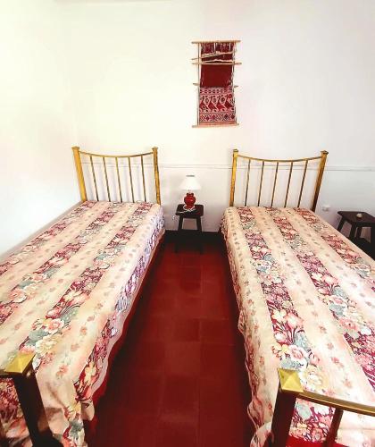 two beds sitting next to each other in a room at Casa Chalet 6 personas in Cosquín