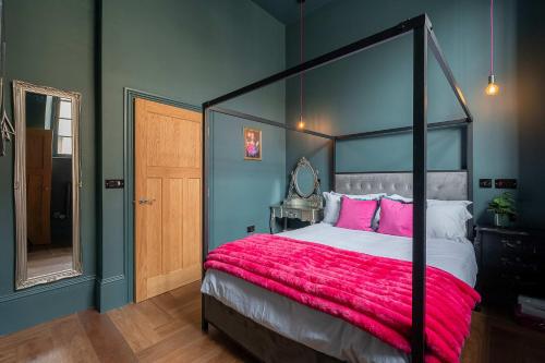 a bedroom with a large bed with a red blanket at Vibrant 2-Bedroom Chapel Retreat in Barnard Castle